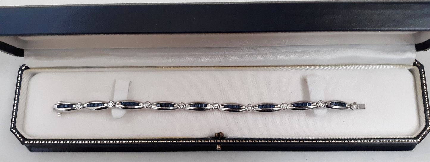 A Lady’s estate 14k white gold diamond and sapphire line bracelet.