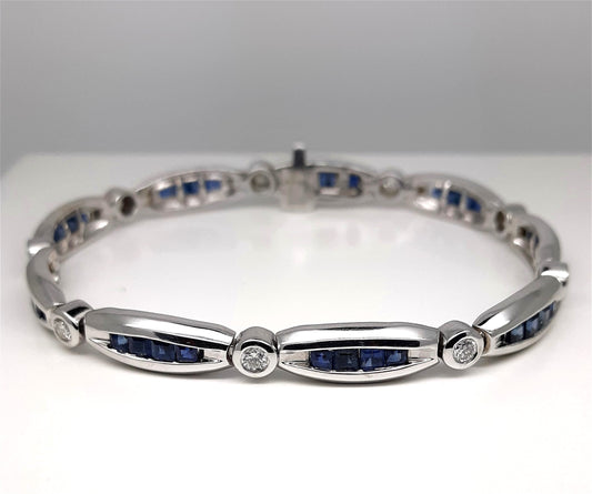 A Lady’s estate 14k white gold diamond and sapphire line bracelet.