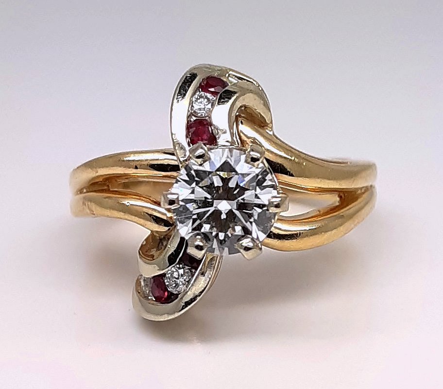 A lady’s estate 14k two tone split shank diamond fashion ring with diamond and ruby accents. Circa: 1990s