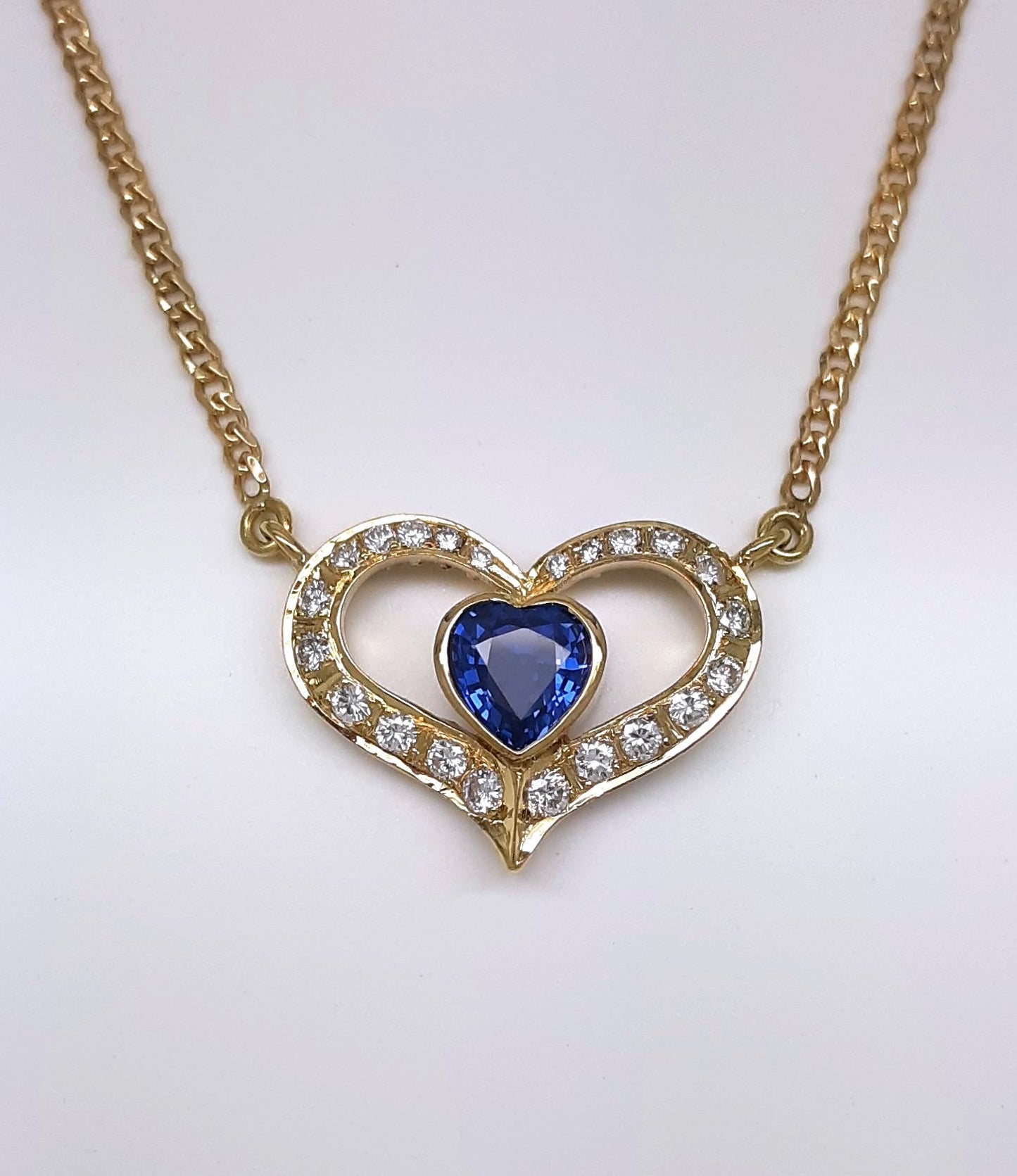 A lady's estate 14k yellow gold 0.73 carat heart shaped Montana Yogo Sapphire and diamond accented pendant on chain.
