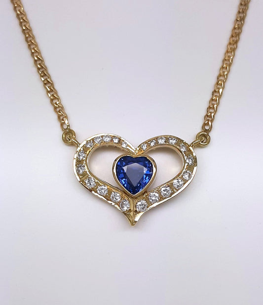 A lady's estate 14k yellow gold 0.73 carat heart shaped Montana Yogo Sapphire and diamond accented pendant on chain.