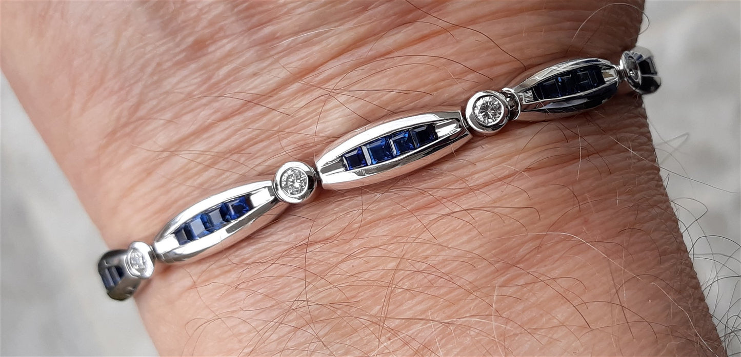 A Lady’s estate 14k white gold diamond and sapphire line bracelet.