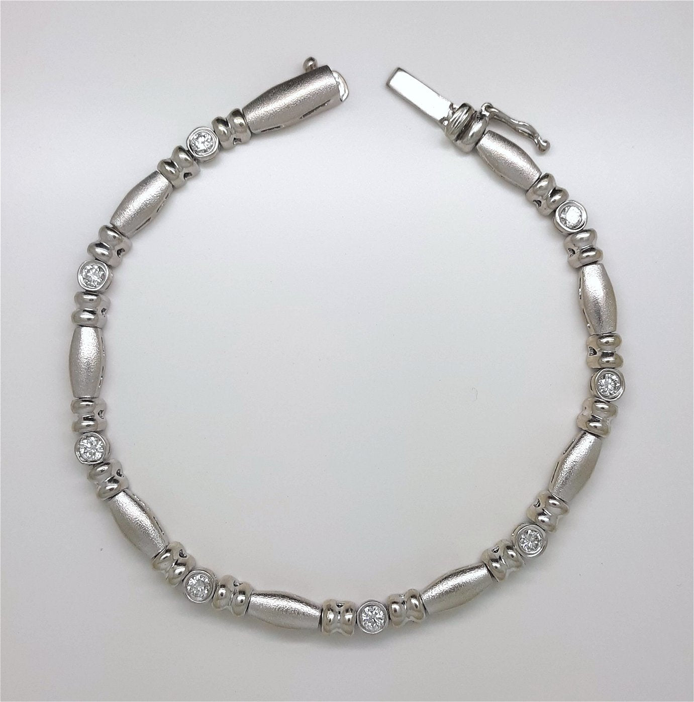 A Lady’s estate 14k white gold diamond accented bead and reel line bracelet.