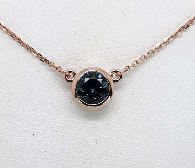 A lady's Minimalist 14k rose gold natural 0.95 carat Montana blue sapphire bezel pendant on chain.