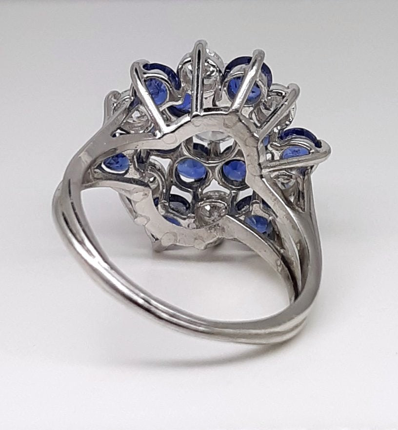 A Lady’s estate 14k white gold natural diamond and sapphire starburst dinner ring. C 1990s