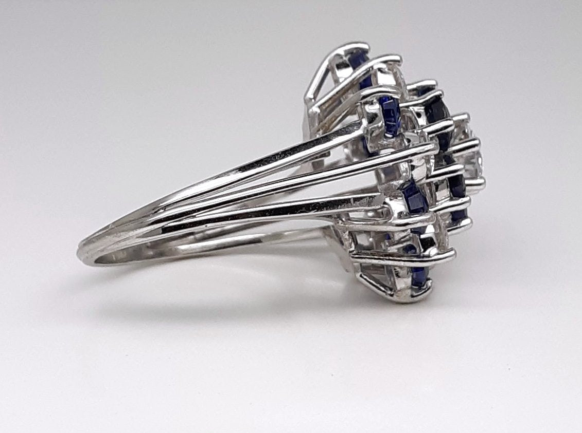 A Lady’s estate 14k white gold natural diamond and sapphire starburst dinner ring. C 1990s