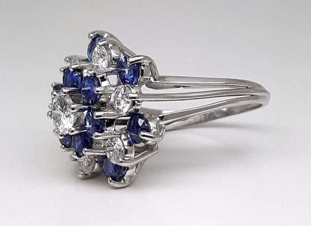 A Lady’s estate 14k white gold natural diamond and sapphire starburst dinner ring. C 1990s