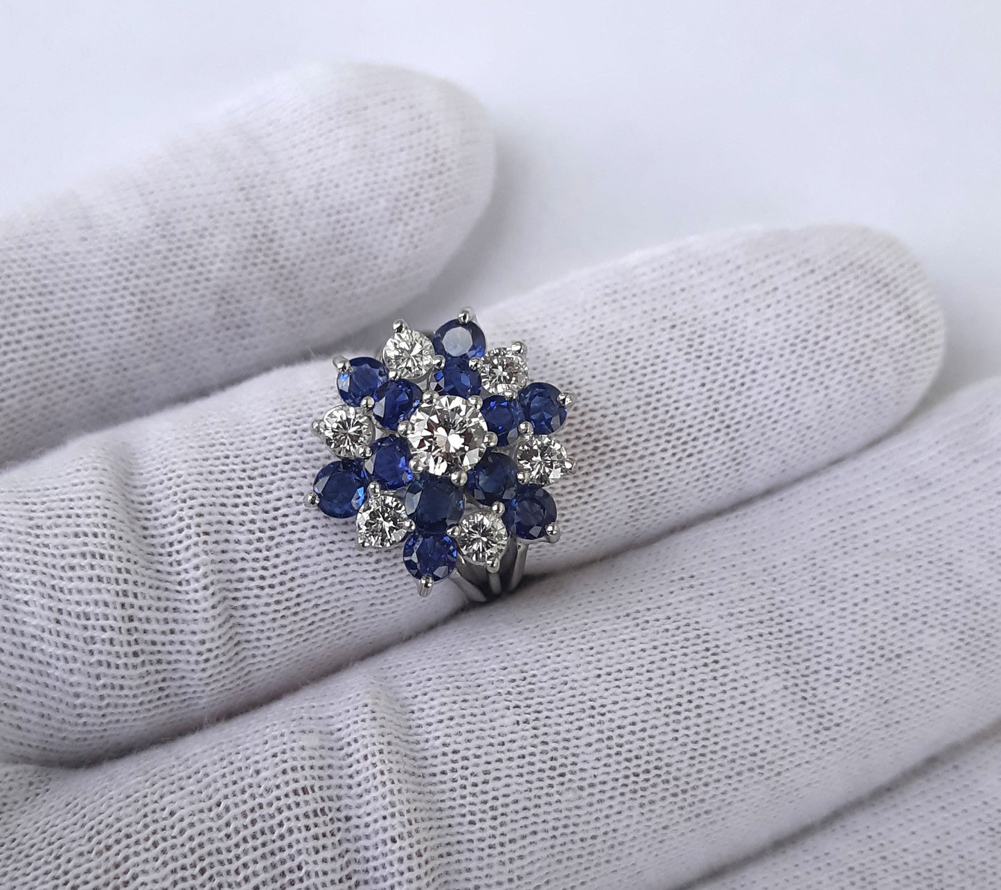 A Lady’s estate 14k white gold natural diamond and sapphire starburst dinner ring. C 1990s