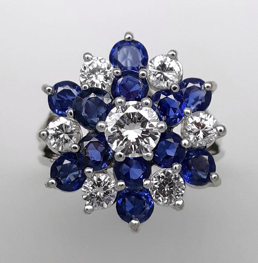 A Lady’s estate 14k white gold natural diamond and sapphire starburst dinner ring. C 1990s