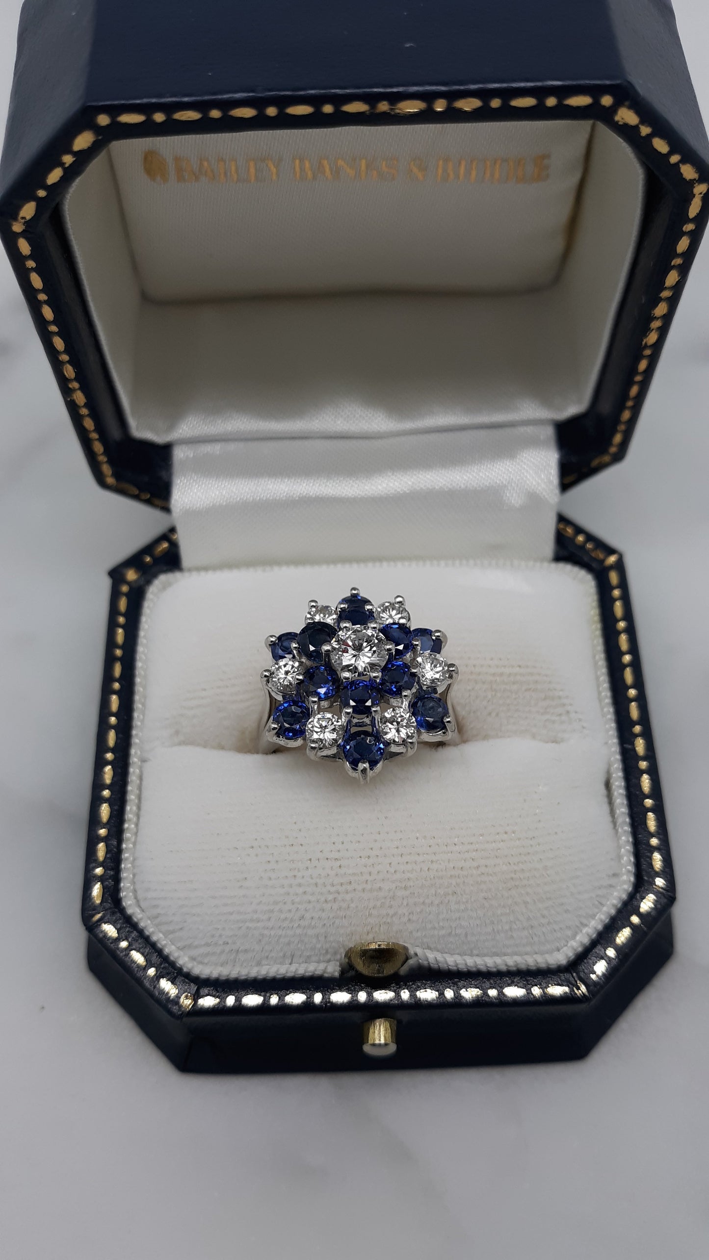 A Lady’s estate 14k white gold natural diamond and sapphire starburst dinner ring. C 1990s